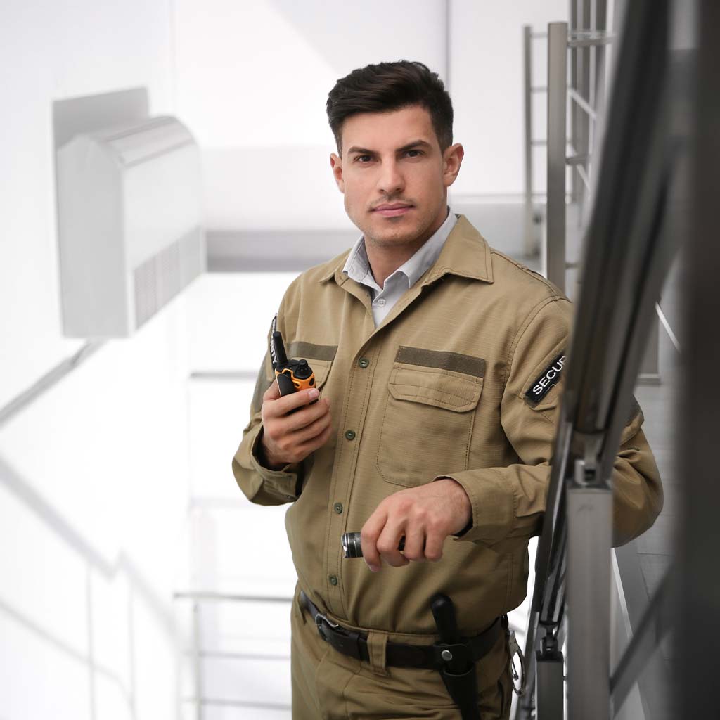 police officer standing in stairway of control room with walkie talkie
